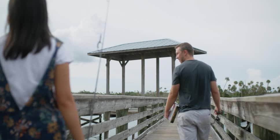 Two people walking down a pier