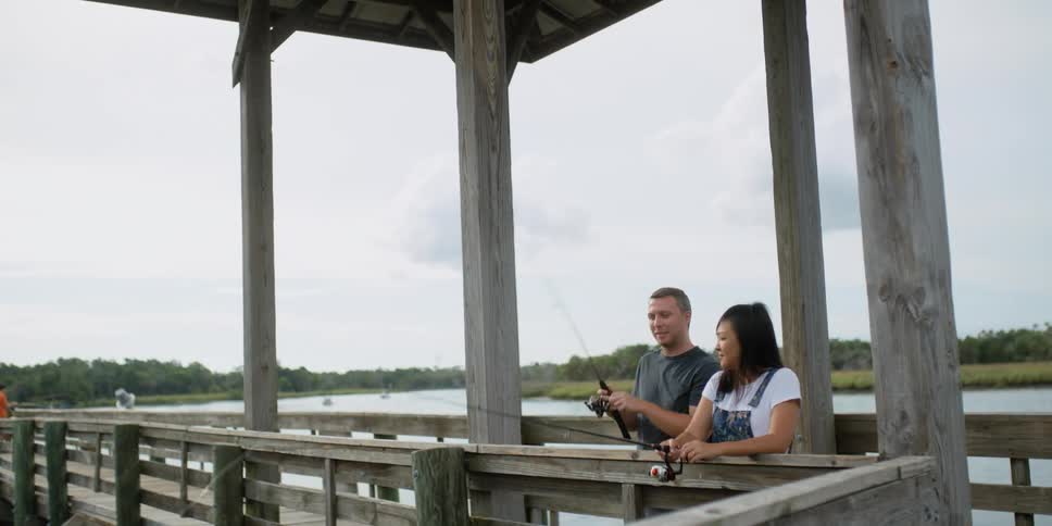 A man and woman fish on the pier
