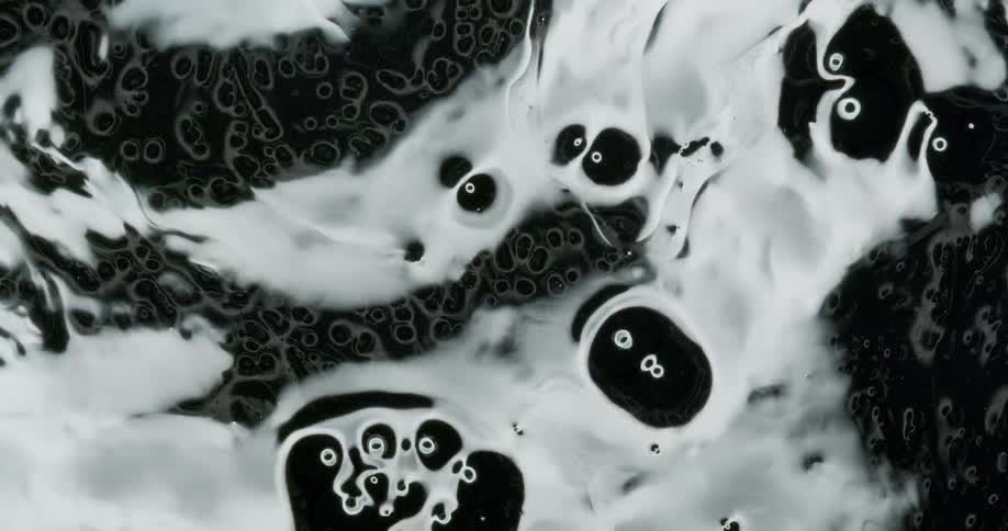 A reflective and viscous black liquid is vibrated which creates unique ripples