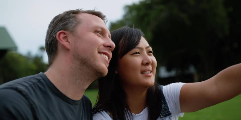 Friends sitting on the backyard talking and smiling while looking at the horizon