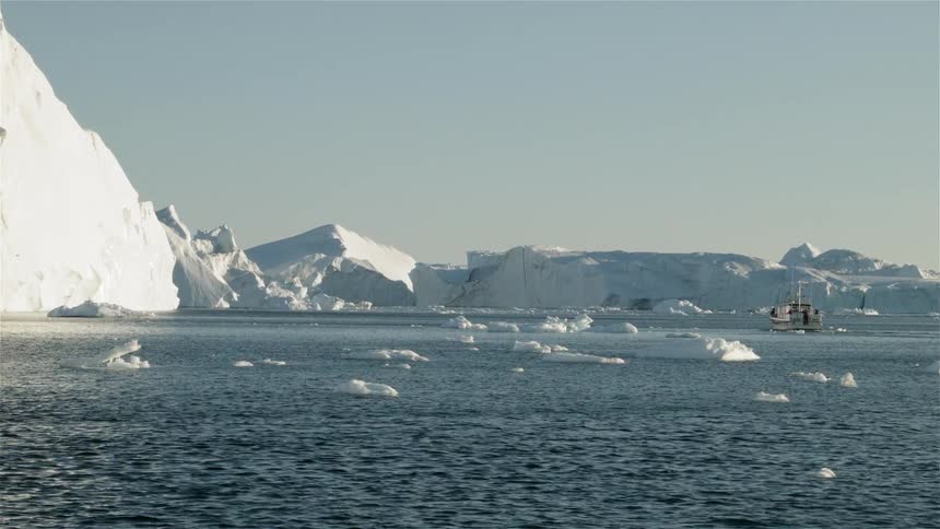 Chunks of ice floating away from a glacier in the daytime