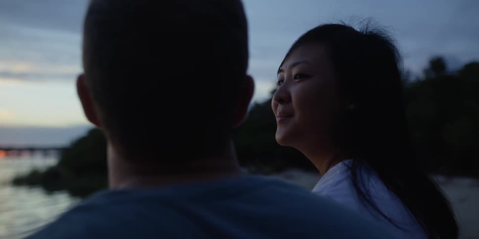 Man and woman are sitting at the beach together