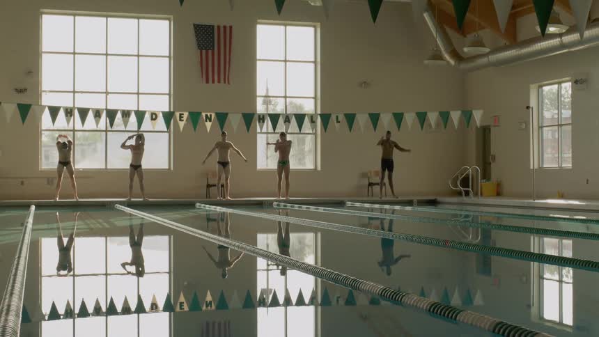 Five men warming up before diving into an indoor pool
