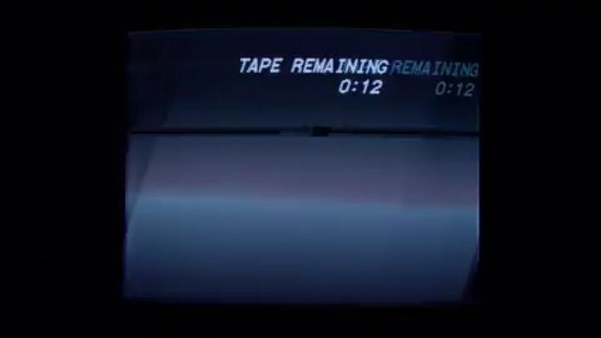 A television screen flickers and plays a countdown while blue light glows around it