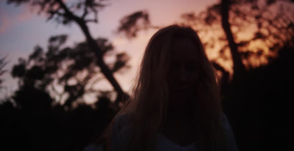 A woman is walking outside at sunset