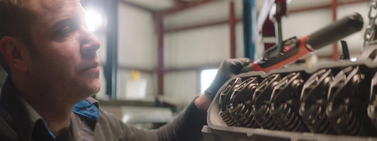 A mechanic inspects the status of some machinery as he lays down a tool
