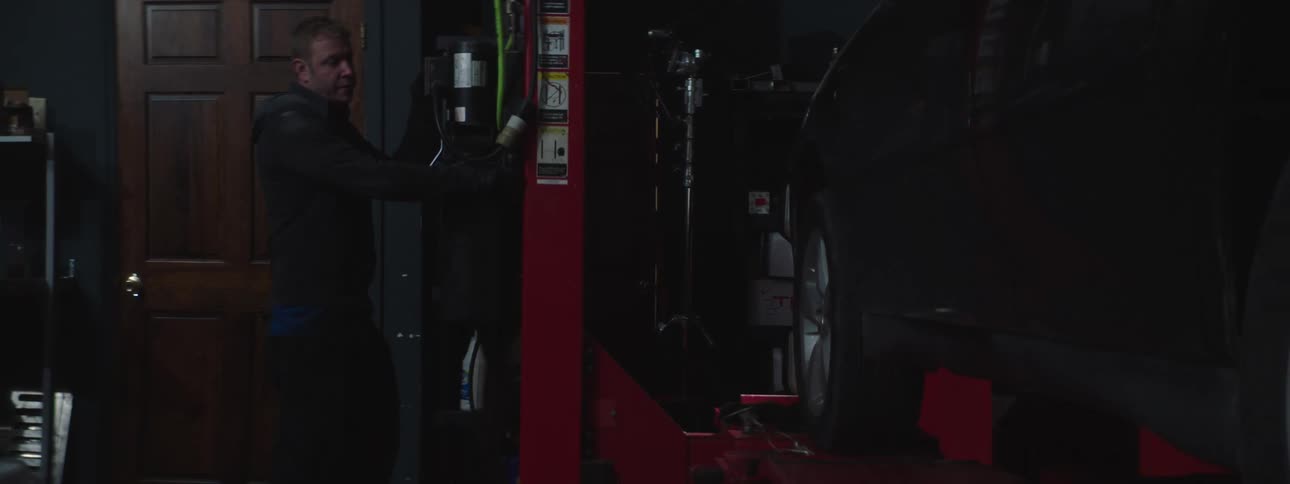 An employee lifting a car on a lift
