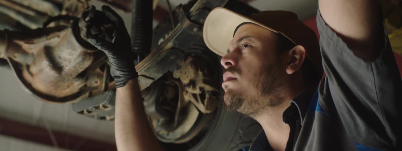A man looking at parts on a car