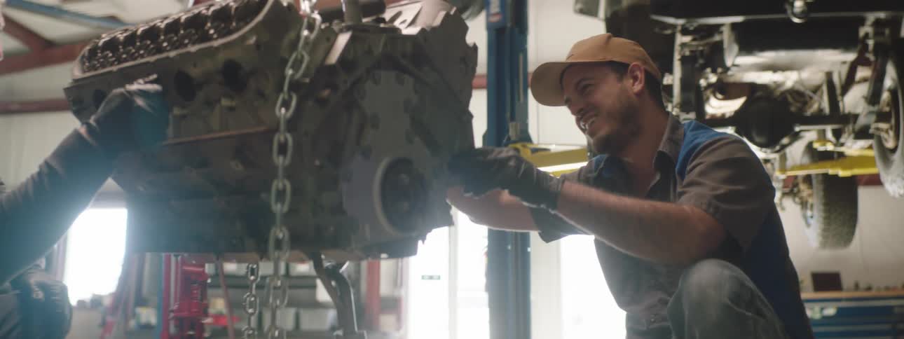 Two people working on an engine