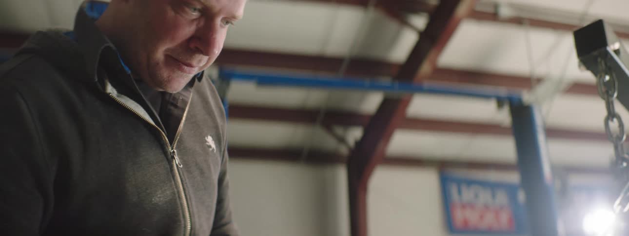 A mechanic is examining a hanging engine
