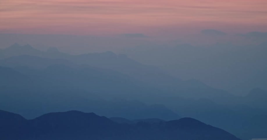 Haze sits over a mountain range during final hours of twilight