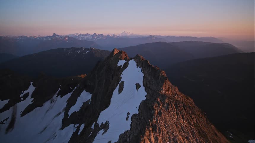 An aerial view of snow covered peaks in a mountain range