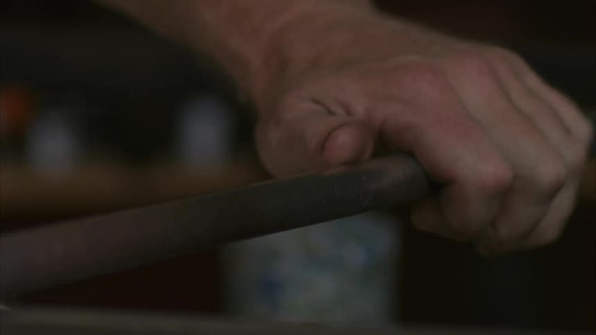 A man rolls a pipe back and forth