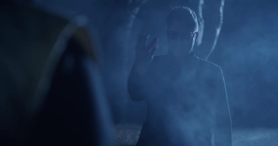 A man in sunglasses points and waves over another man