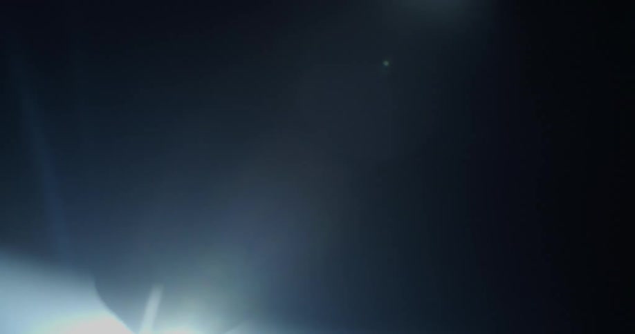 A drummer is playing under the spotlight