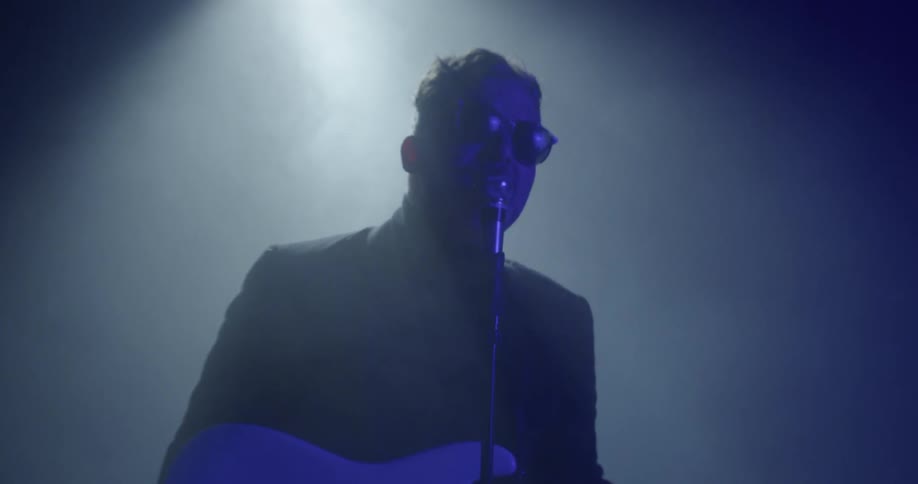 A man playing a guitar on a stage