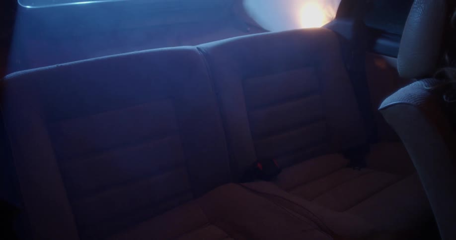 Bright lights shining into the backseat of a car