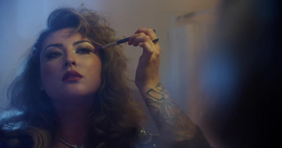 A woman putting on makeup in a mirror