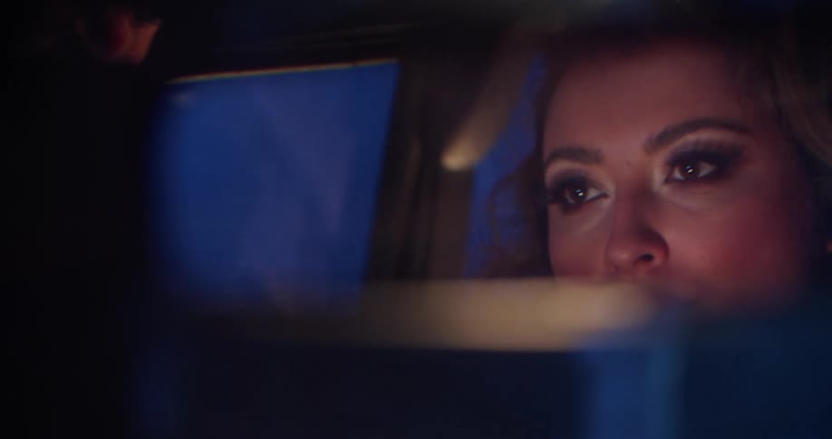 Rear view mirror reflects woman driving car through foggy night