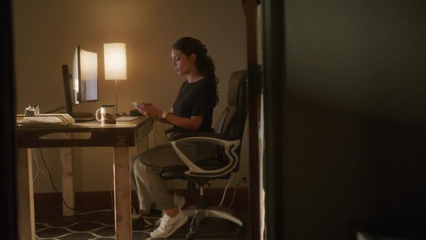 A woman using a computer before using a cell phone