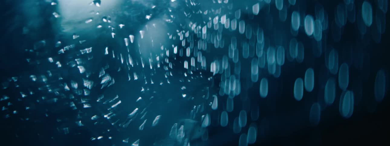 Light reflecting on water droplets suspended in distorted glass