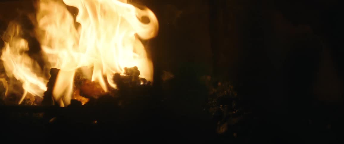 Long staff is used to stir roaring fire
