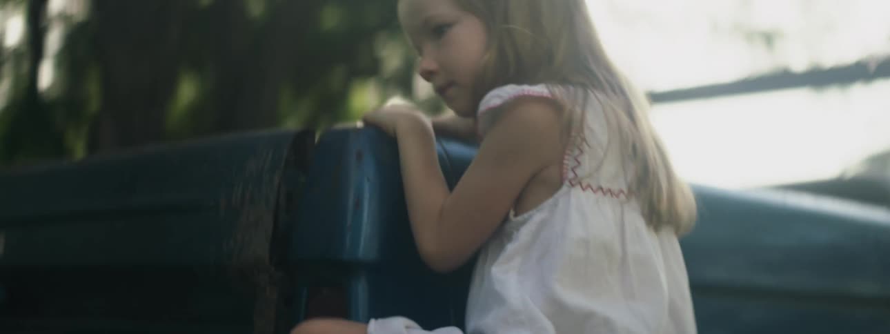 A young girl climbing on a truck