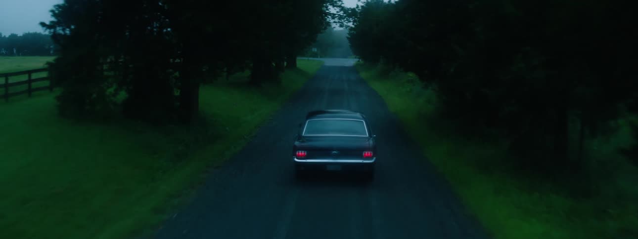 A car drives down the road on a foggy day