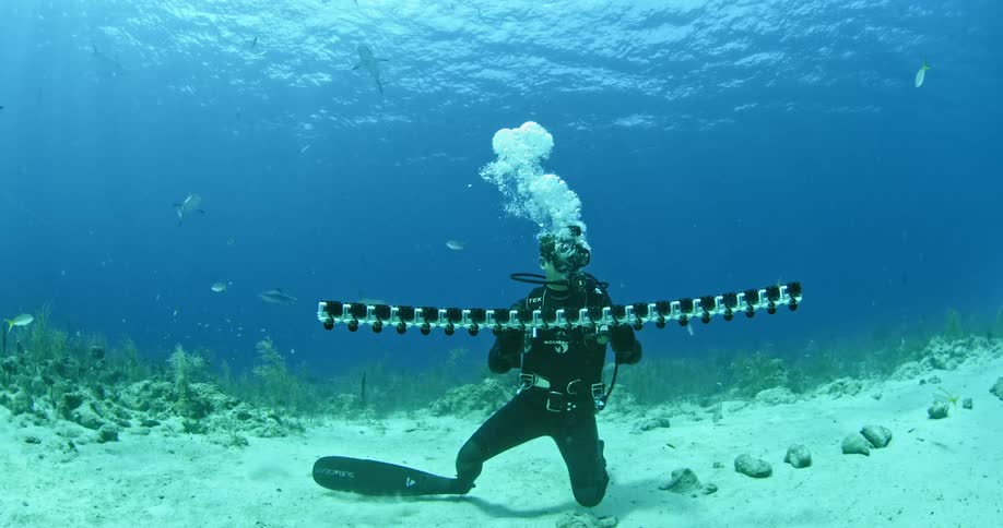 Diver standing on ocean floor with camera device