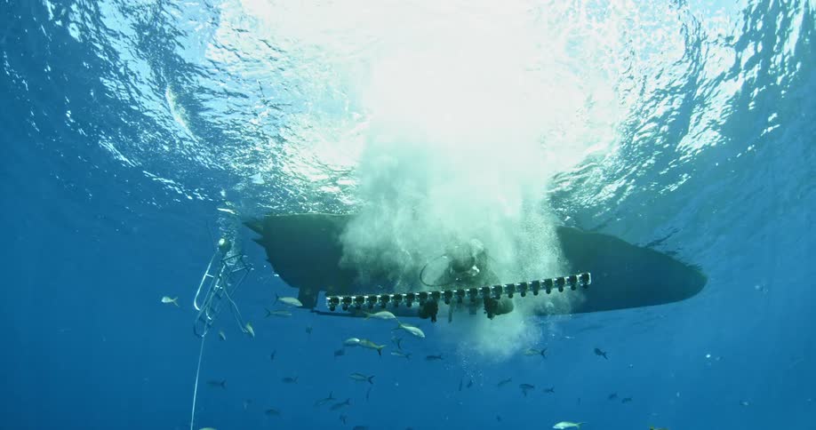Diver jumping into ocean and swimming underwater with camera device