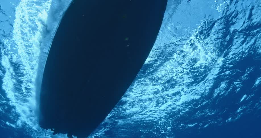 From underwater a boat i traveling in the water above