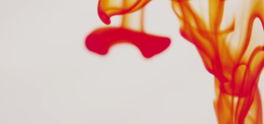 Red liquid flows down a white background