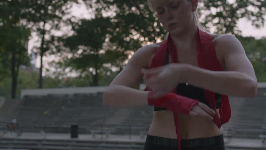 A woman wraps her hand with athletic tape