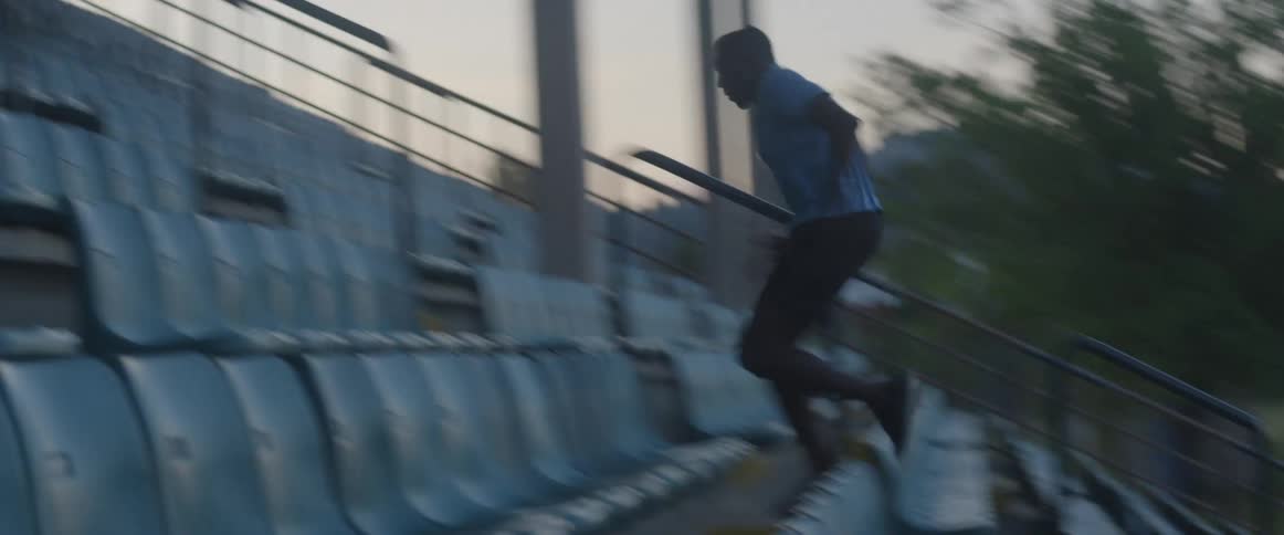 Man runs up bleacher seats at night