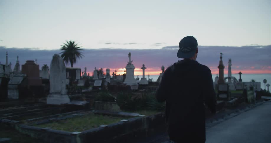 A man is jogging through the cemetery