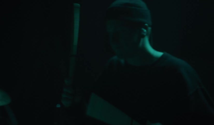 Drummer plays drums on stage under colored lights