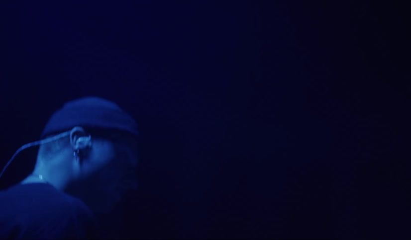 A man is playing the drums and wearing a hat
