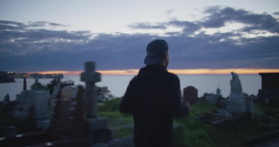 A man jogs through a cemetery at sunset