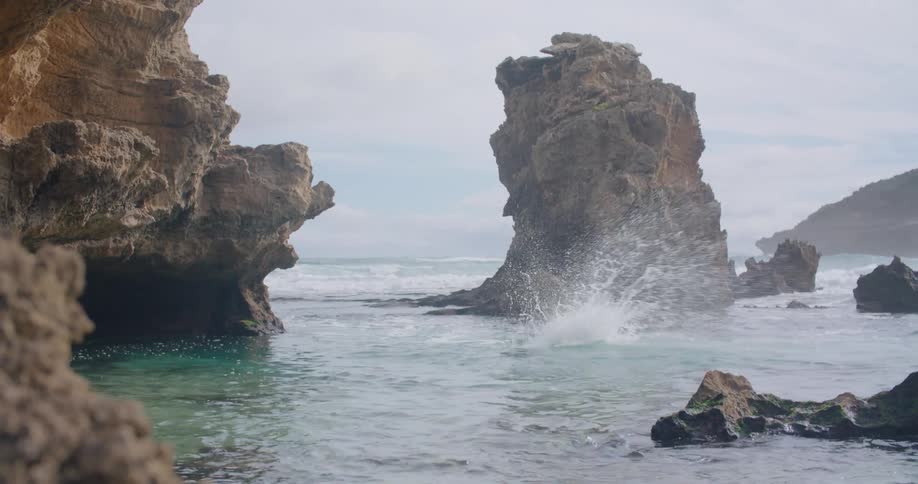 A man jumping off a cliff into a lagoon with the sky and clouds in the background