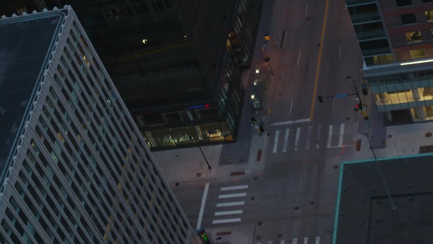 A vehicle travels through an intersection in a metropolis in the evening