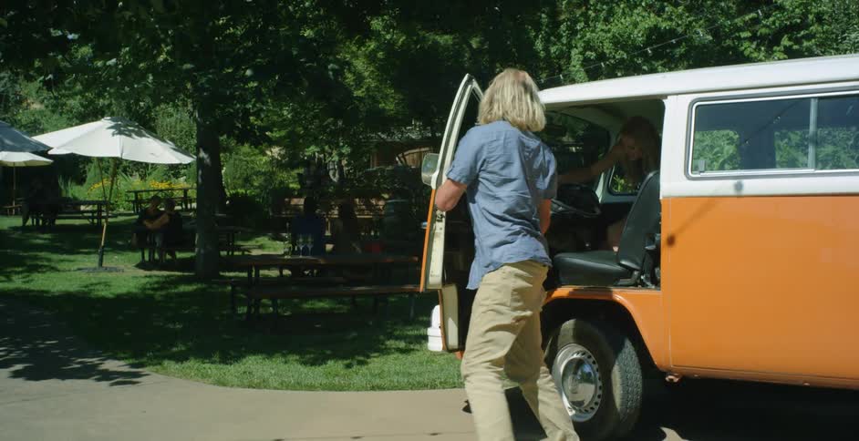 Person gets out of an orange van at a park