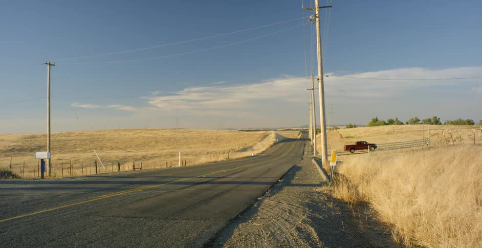 An orange van turns onto a rural road