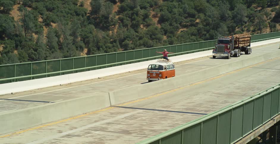 Vehicles drive down a large highway during the day
