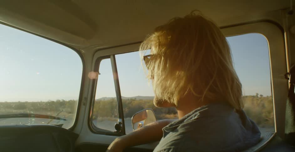 A man wearing sunglasses sits in the van