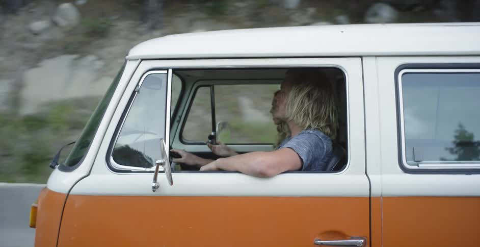 A man drives a van on a rural road