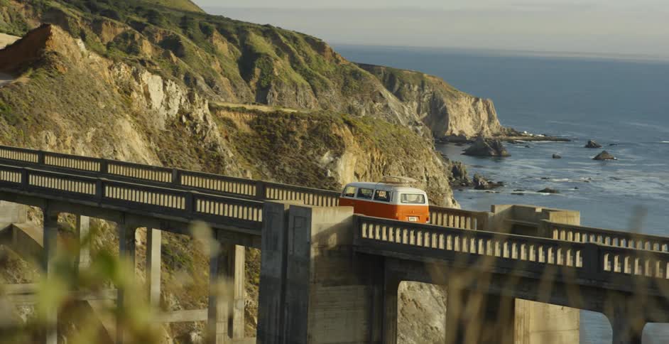 A volkswagen bus is driven over a bridge