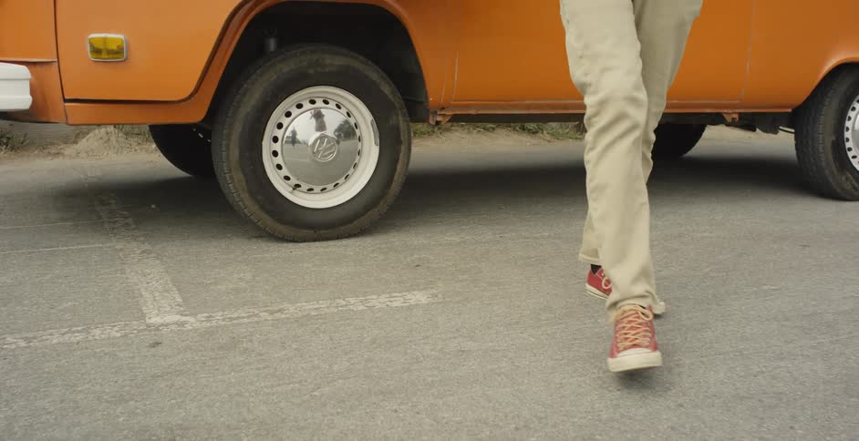 A man exits an orange van