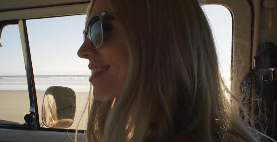 A woman smiles while riding in a car