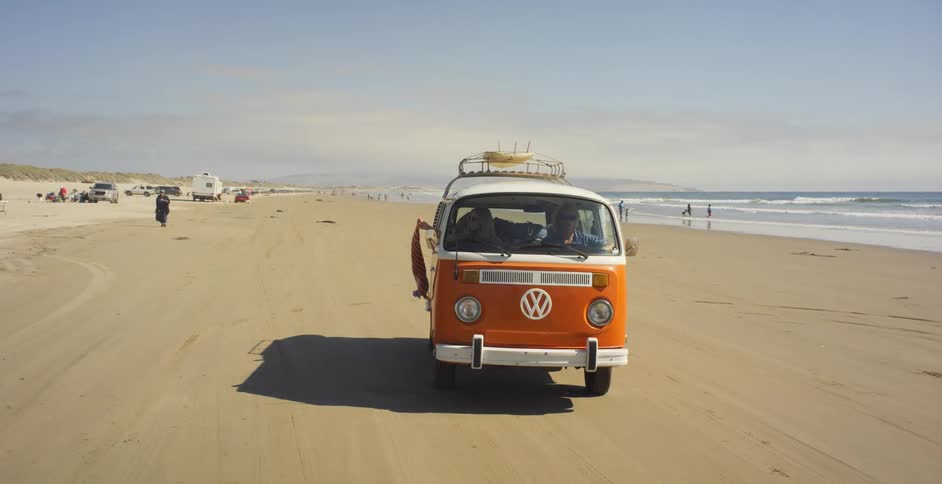 A volkswagen bus is driven on a beach