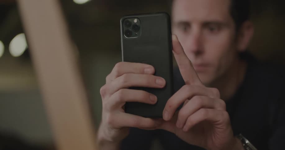 A man taking a photo of something in a shop with a smartphone